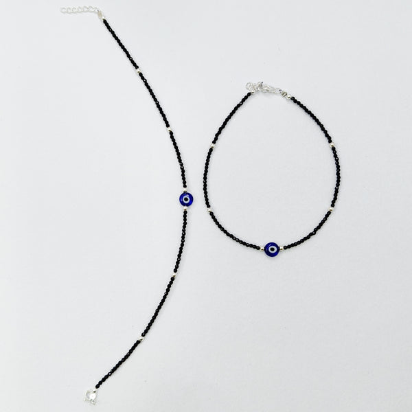 Black beaded anklet with blue beads on a white background