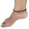 Anklet with a blue evil eye bead on a foot against a white background