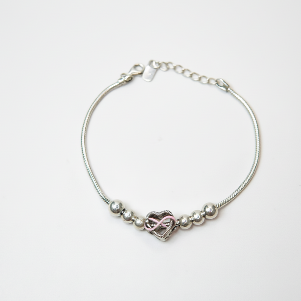 Silver beaded bracelet featuring a rose-gold infinity heart charm displayed on a white background.