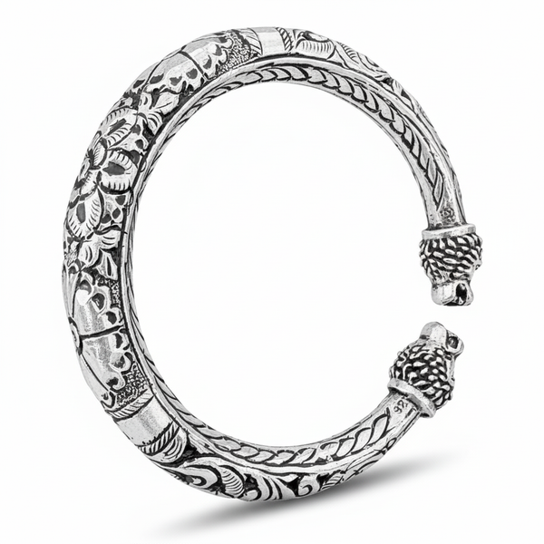 Silver bracelet with intricate designs on a white background