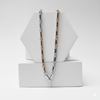 Necklace with alternating silver and rose gold links on a white geometric stand.