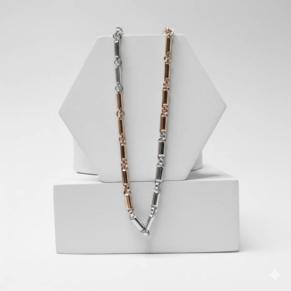 Necklace with alternating silver and rose gold links on a white geometric stand.