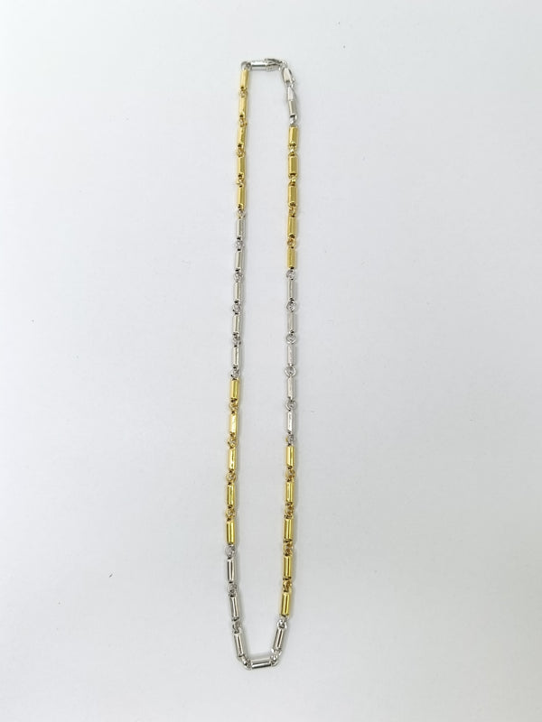 Two tone necklace, one gold and one silver, on a white background