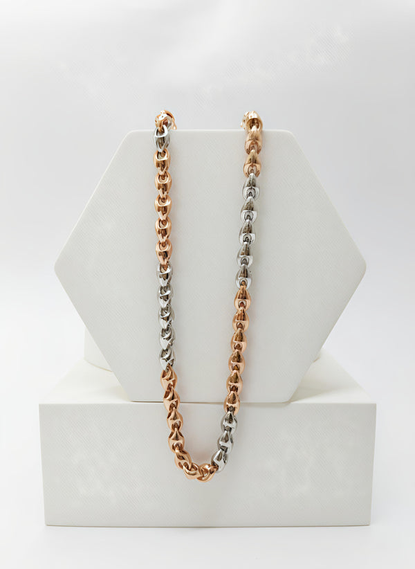 Two-tone chain necklace in silver, rose gold, and gold on a white stand.