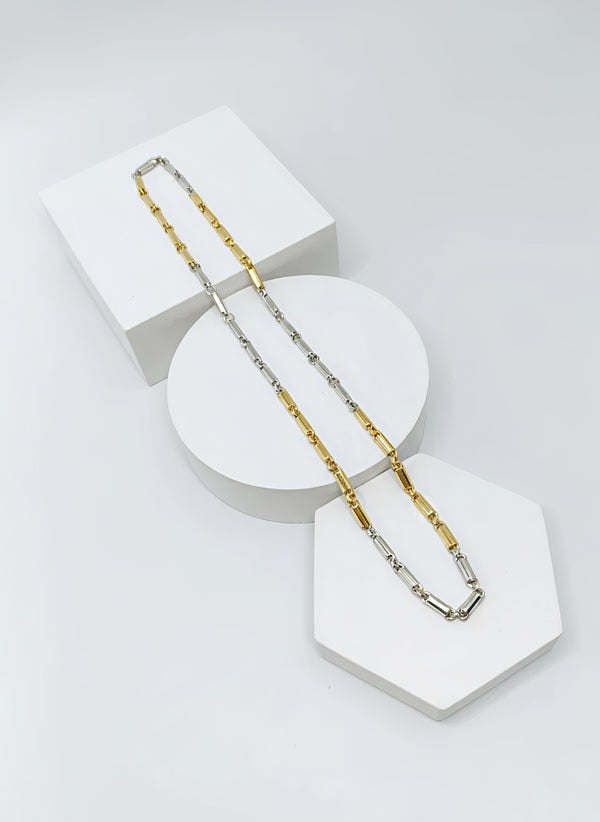 two tone Gold and silver chain necklace on a white geometric display