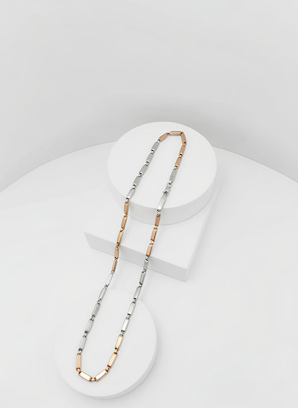 Two-tone silver and goldnecklace on a white stand with a light gray background