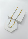 two-tone silver and gold chain necklace on a white stand with a white background