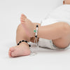 Pair of silver-plated black beaded anklets with green floral charm pendants, handcrafted traditional Indian jewelry for kids, adjustable thread design displayed on white background.