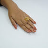 Hand wearing a gold ring on a white background