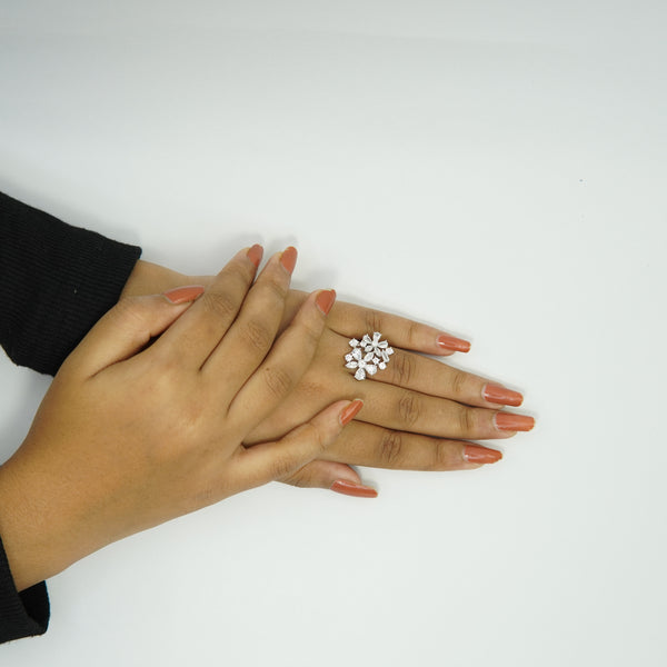 Elegant floral diamond cluster ring for women with sparkling cubic zirconia stones, silver-plated adjustable band displayed on hand with nude nail polish.