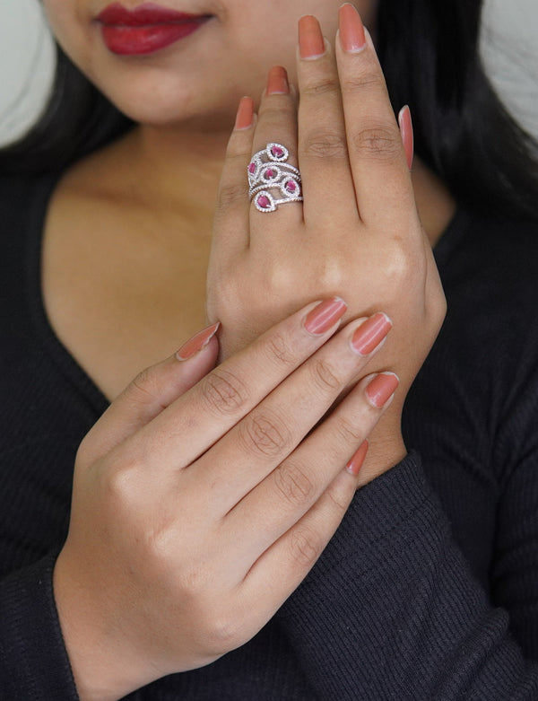 Sterling silver adjustable butterfly ring with pink teardrop gemstones, elegant handcrafted jewelry for women displayed on hand with nude nail polish, designer fashion accessory.