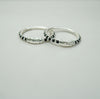 Two kids silver bangles with black beads on a light gray background