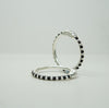 Two silver kids bangle with black beads on a light gray background