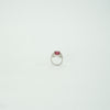 Silver ring with a red gemstone on a light gray background