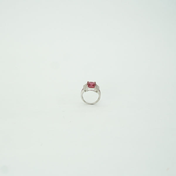 Silver ring with a red gemstone on a light gray background