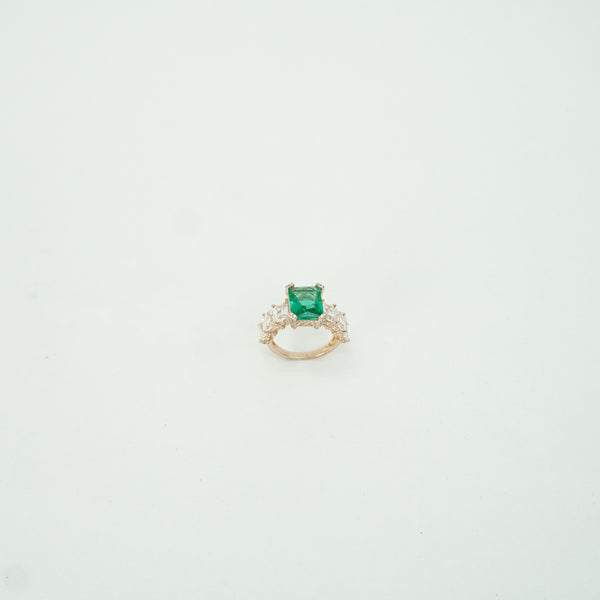Ring with a green gemstone on a light gray background