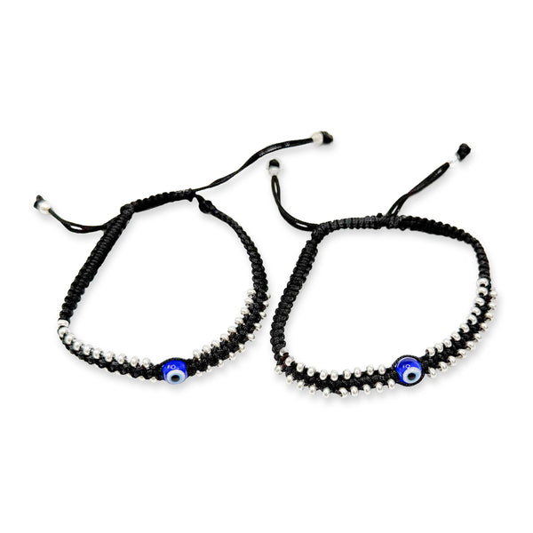 Two black beaded bracelets with blue evil eye charms on a white background