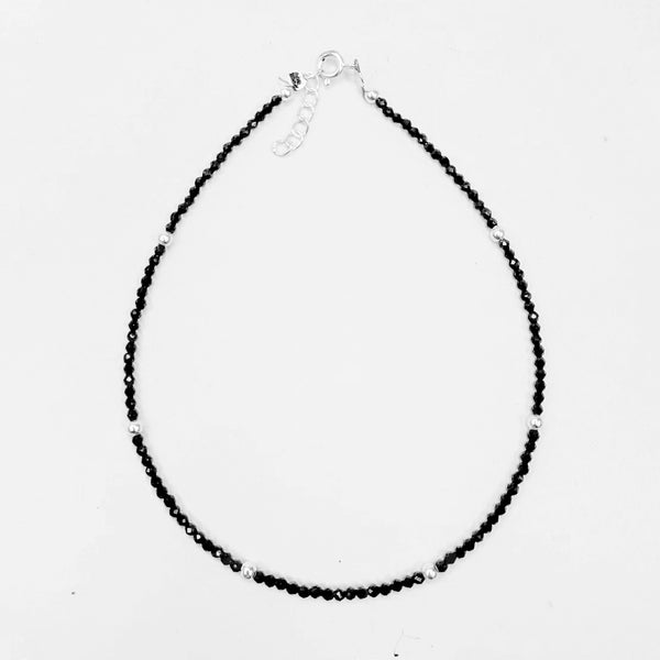 Black beaded necklace on a white background