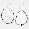 Two silver beaded anklets with blue evil eye beads on a white background