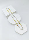 two tone Gold and silver chain necklace on a white geometric display