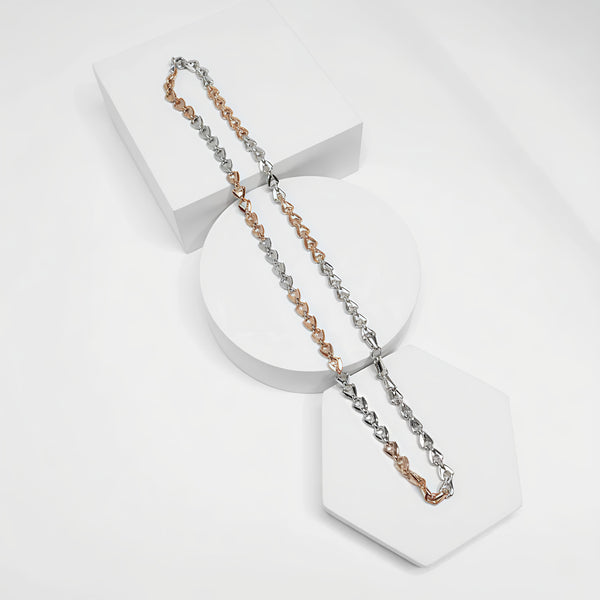 Two tone necklaces in silver and rose gold on a white stand with a white background