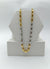 Gold and silver chain necklace on a white stand with a white background