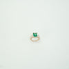 Ring with a green gemstone on a light gray background