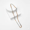 Two-layered necklace with gold, silver, and rose gold tones on a white background