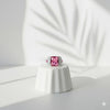 Ring with a pink gemstone on a white pedestal against a light background